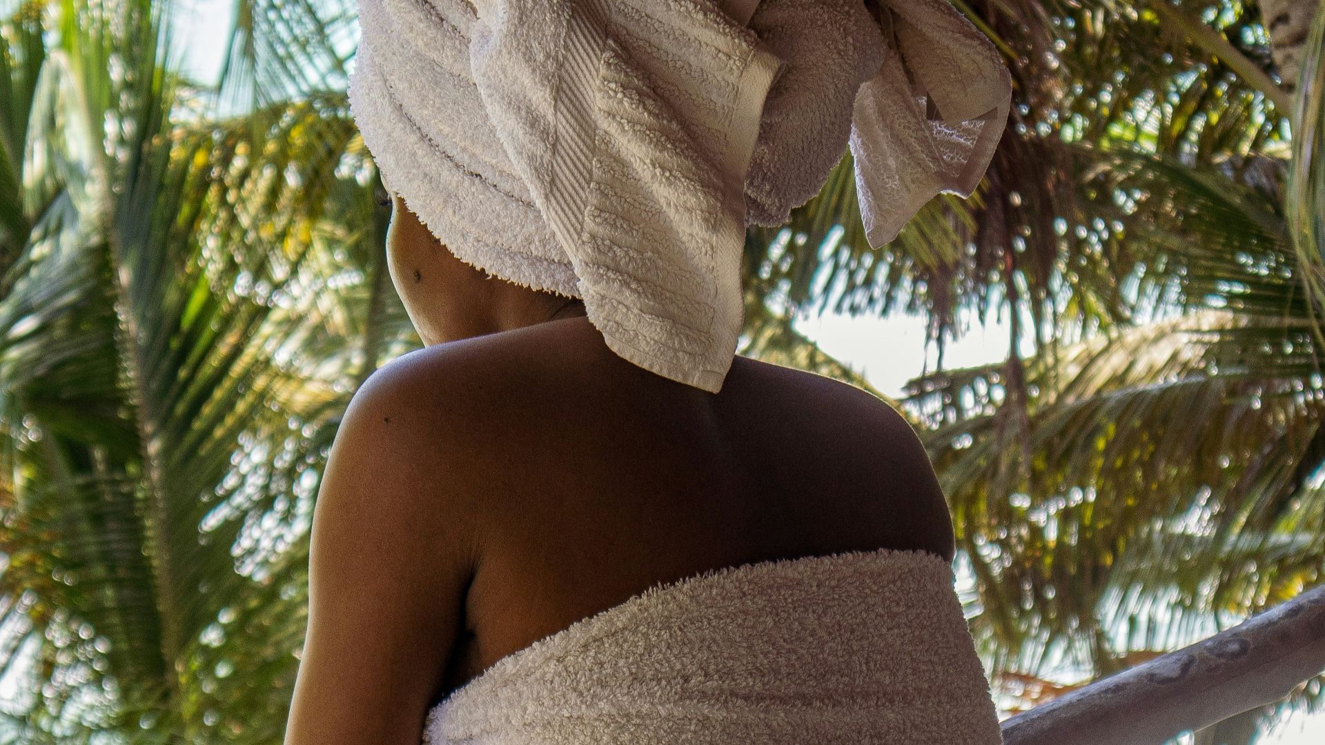 woman in white towel covering her face