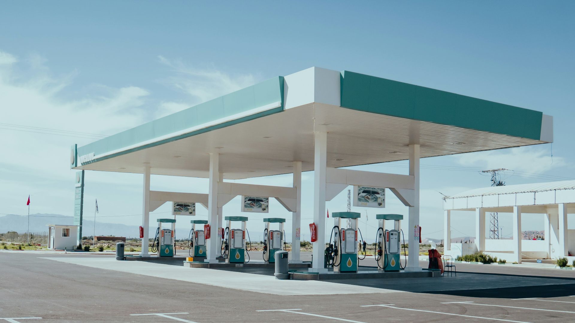 a row of gas pumps sitting in a parking lot