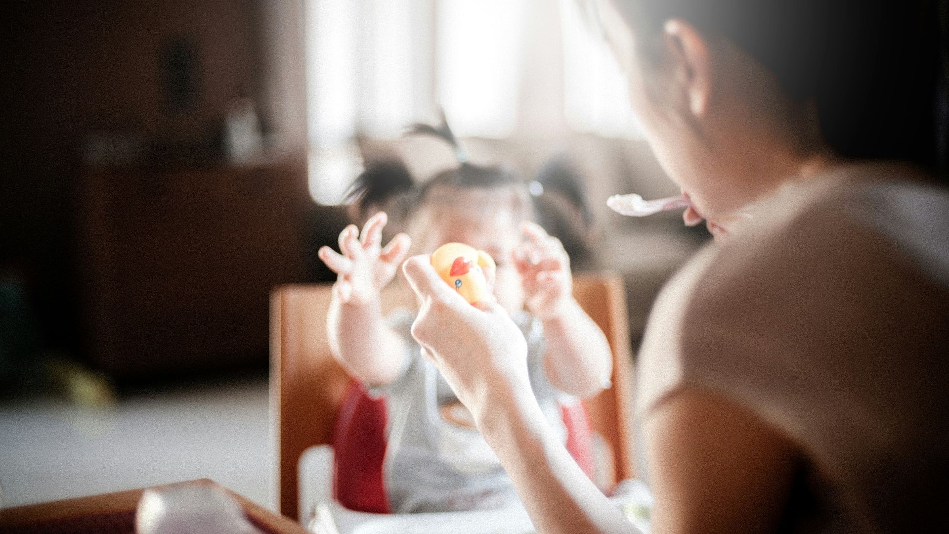selective focus photography of woman feeding baby