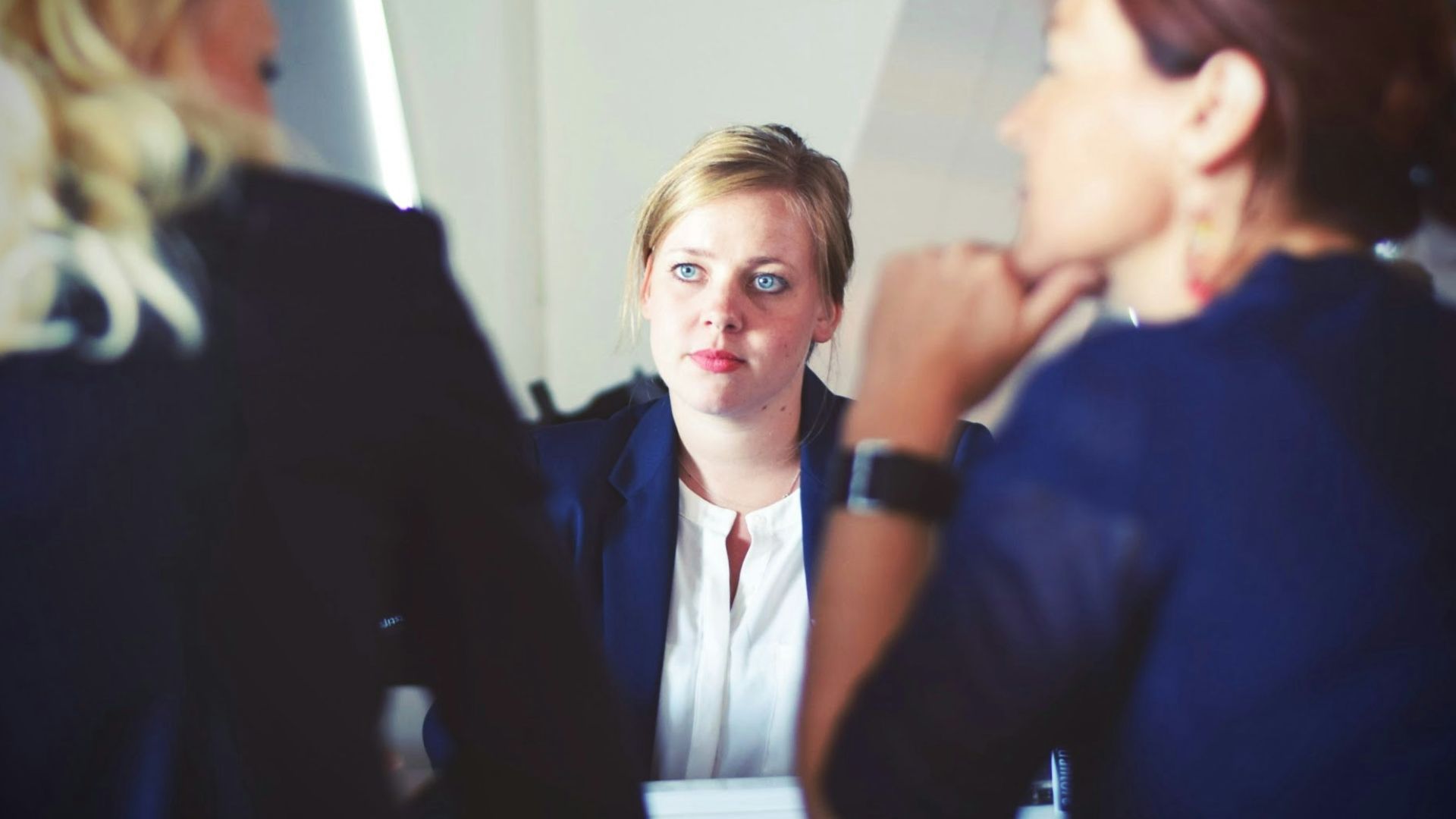 three women sitting beside table