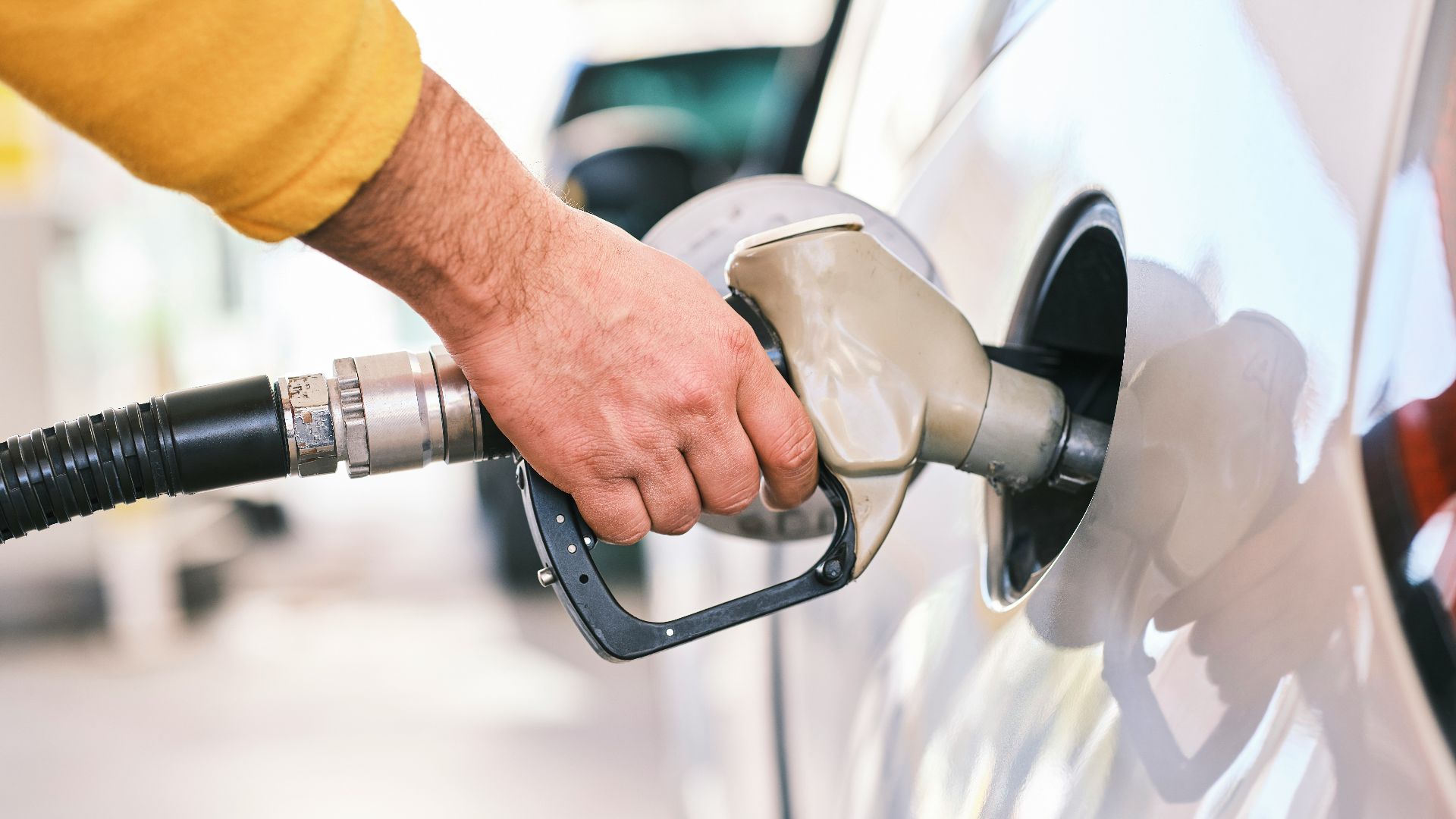 a man pumping gas into his car at a gas station
