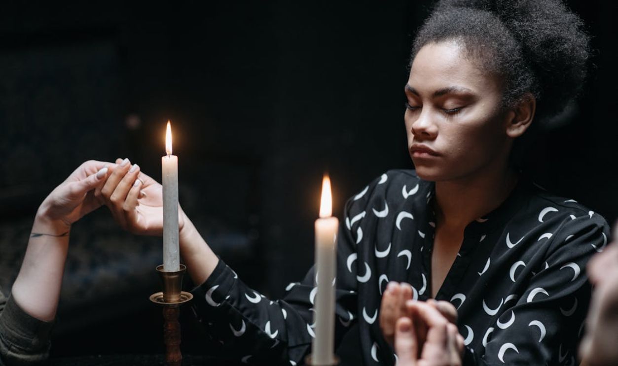A Woman Wearing Black Printed Long Sleeves Near Burning Candles