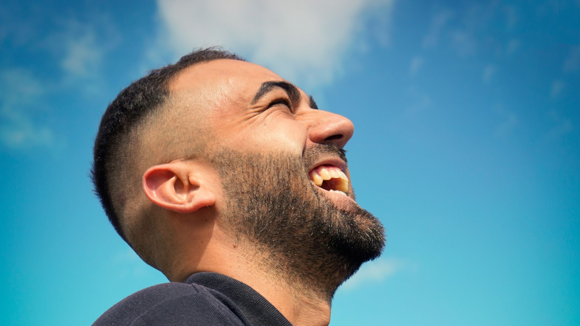 smiling man wearing black collared top