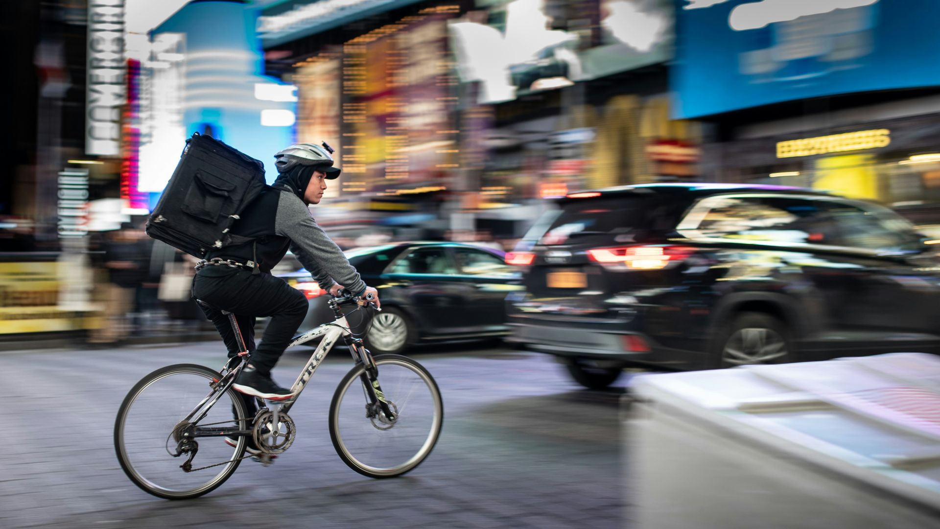 man riding bicycle near vehicles
