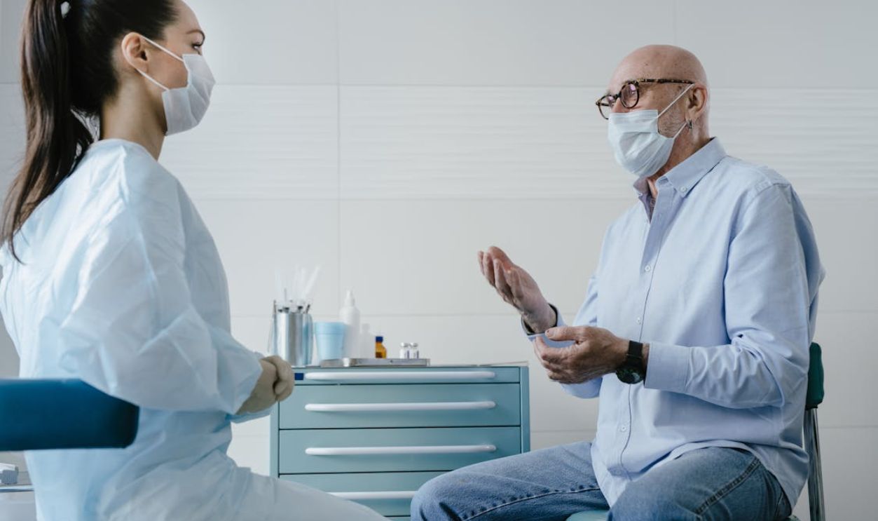 Elderly Man Patient talking at his Doctor