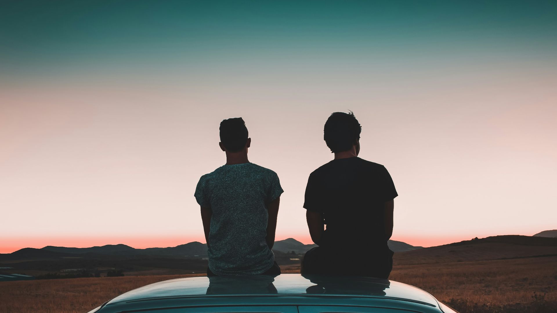 two men sitting on vehicle
