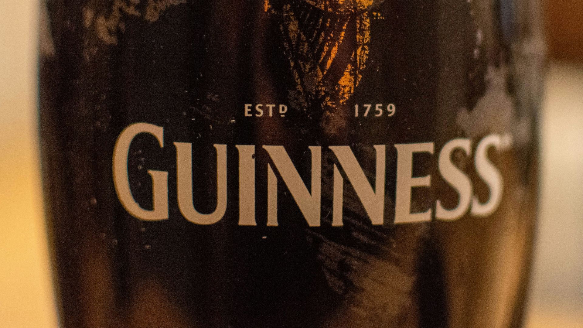 a glass of beer sitting on top of a table