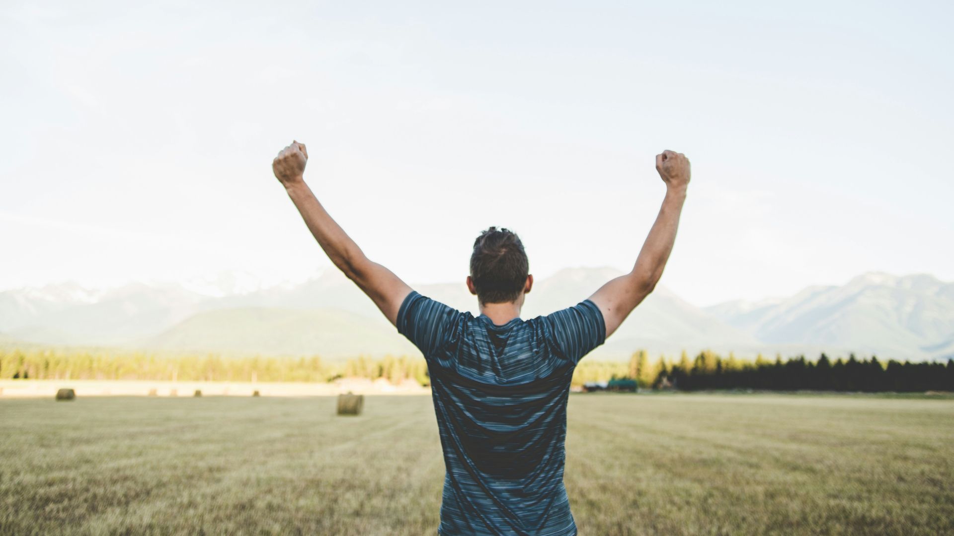 man reaching hands up high taken at daytime