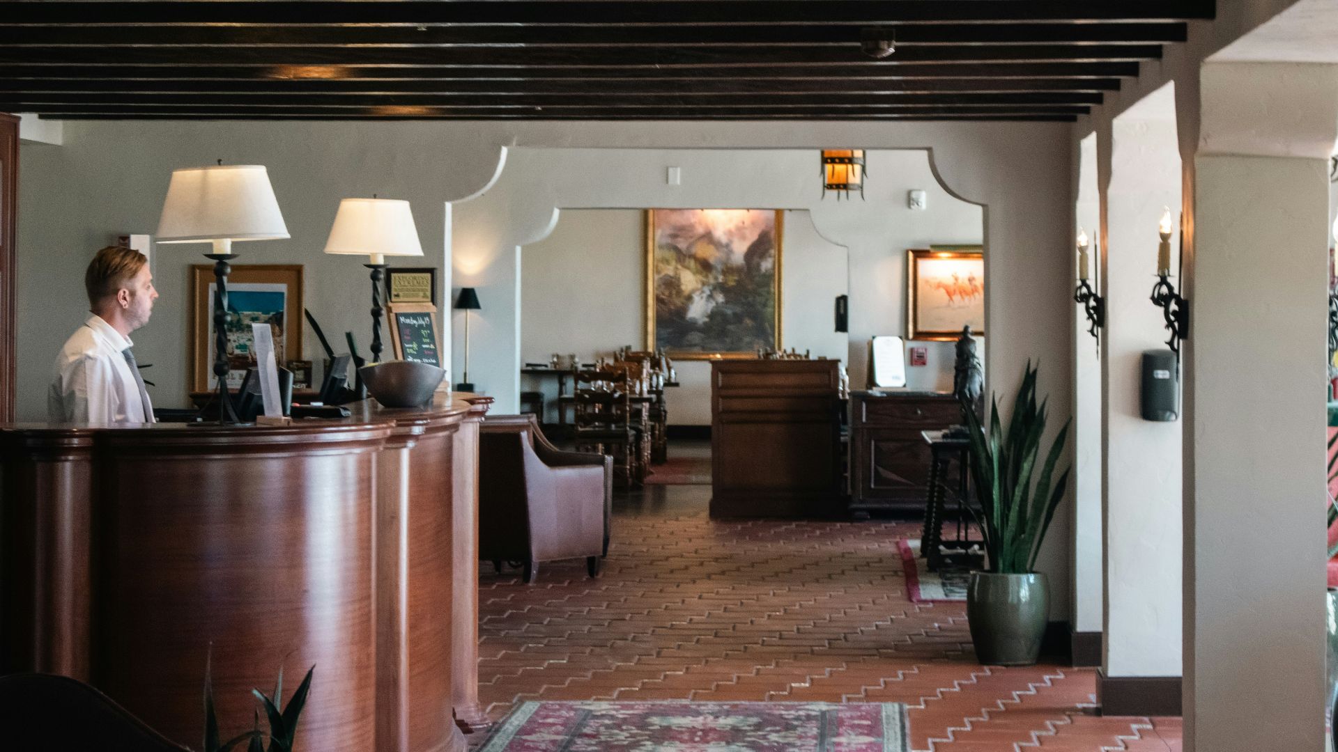 A woman is standing at the front desk of a restaurant