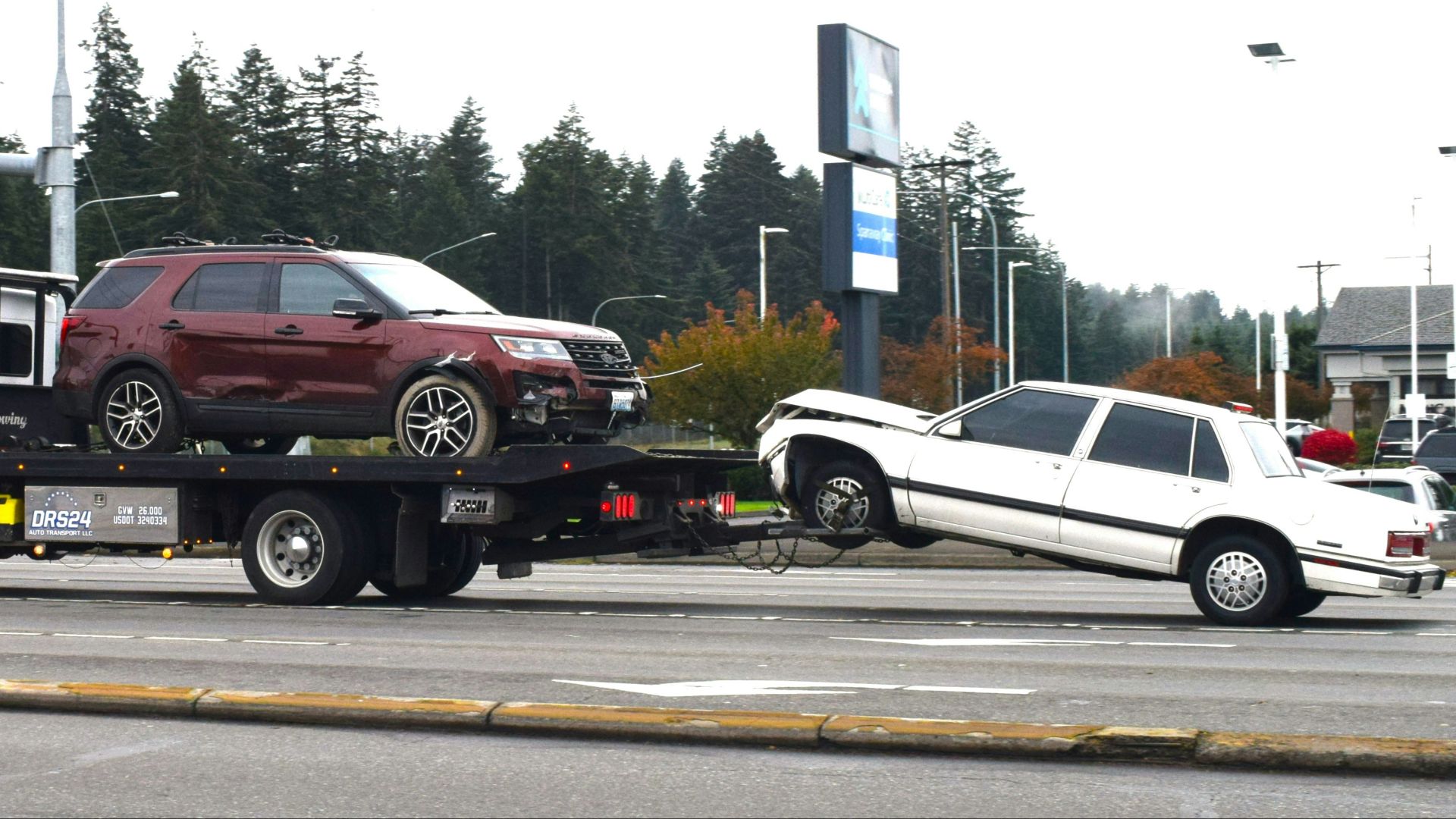 A tow truck towing a car on a flatbed