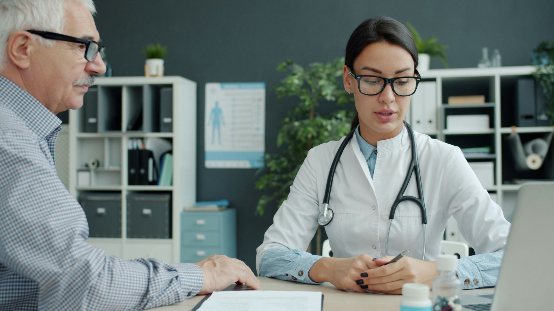 Doctor consulting with an elderly patient in an office.