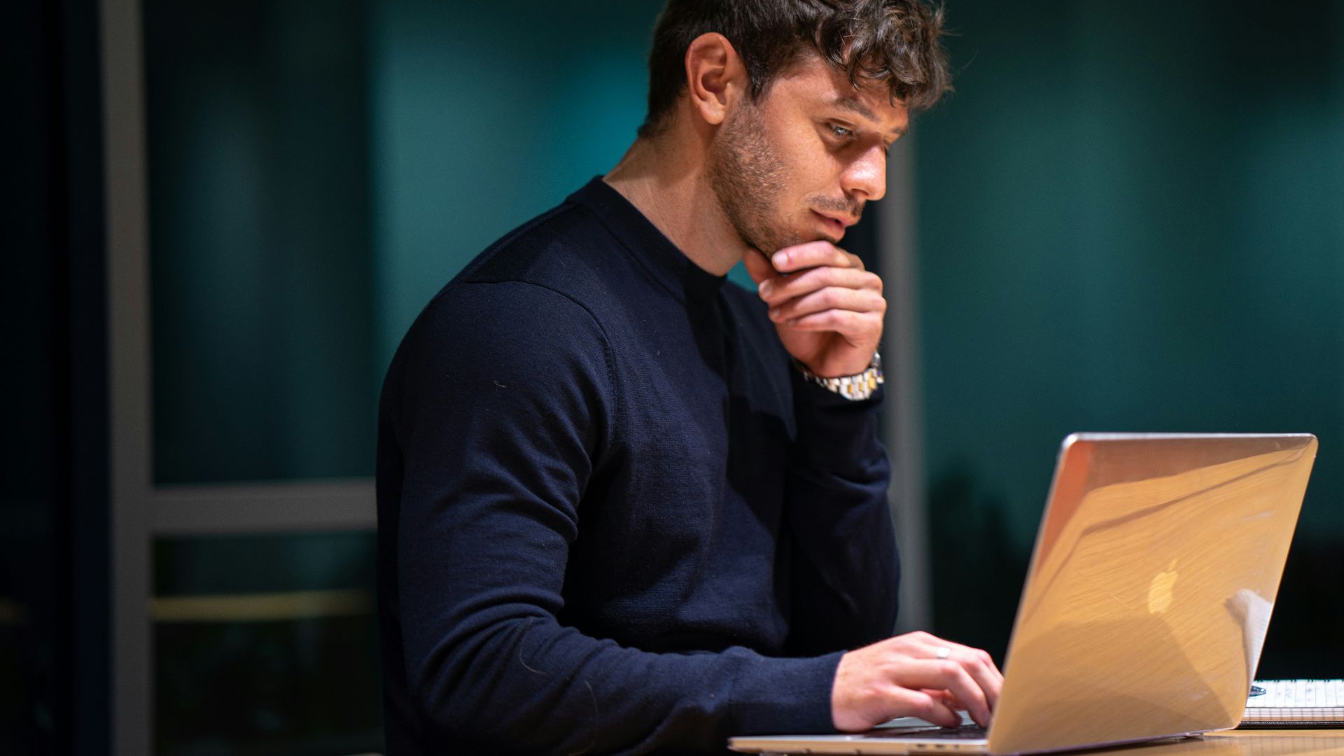 man in black long sleeve shirt sitting in front of macbook