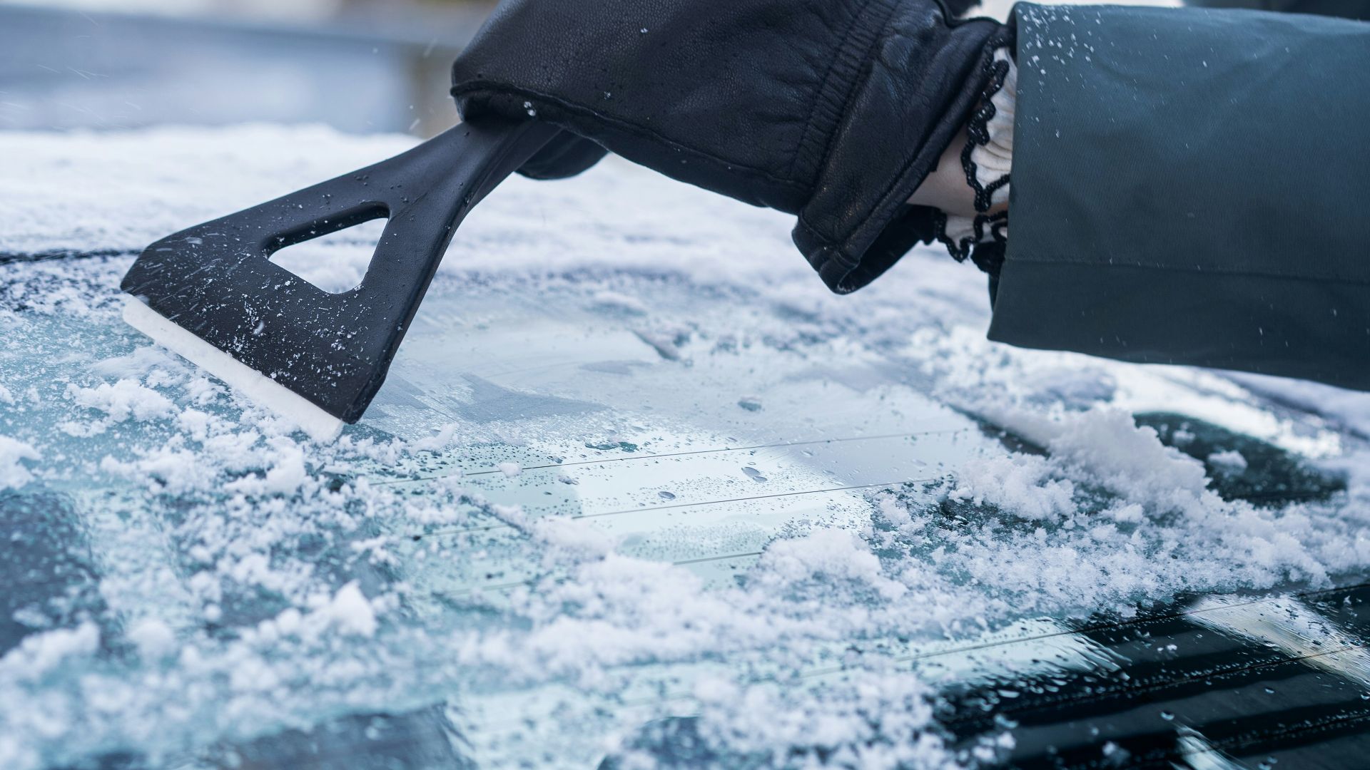 A person with a snowboard on top of a car