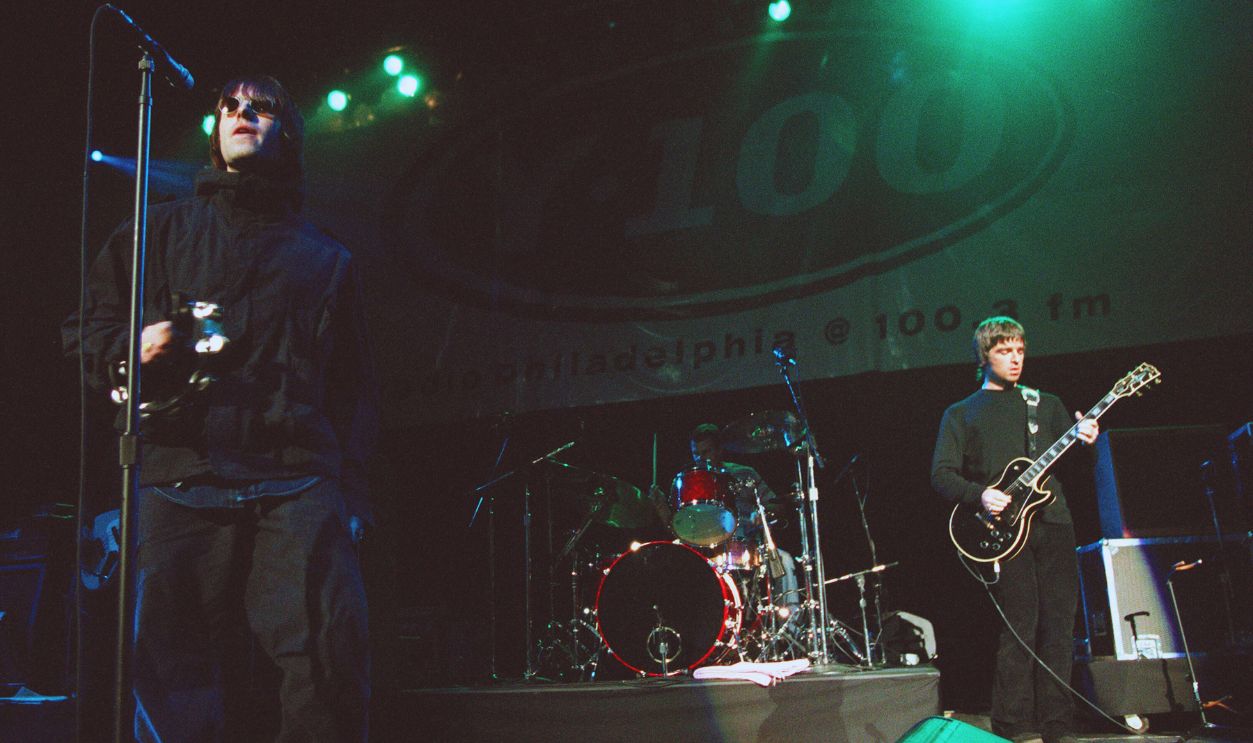 Gettyimages - 51129202, Oasis Play Live PHILADELPHIA - DECEMBER 3: Singer Liam Gallagher (L) and brother Noel Gallagher from Oasis on stage for 100fm Radio show on December 3, 1999 in Philadelphia. 