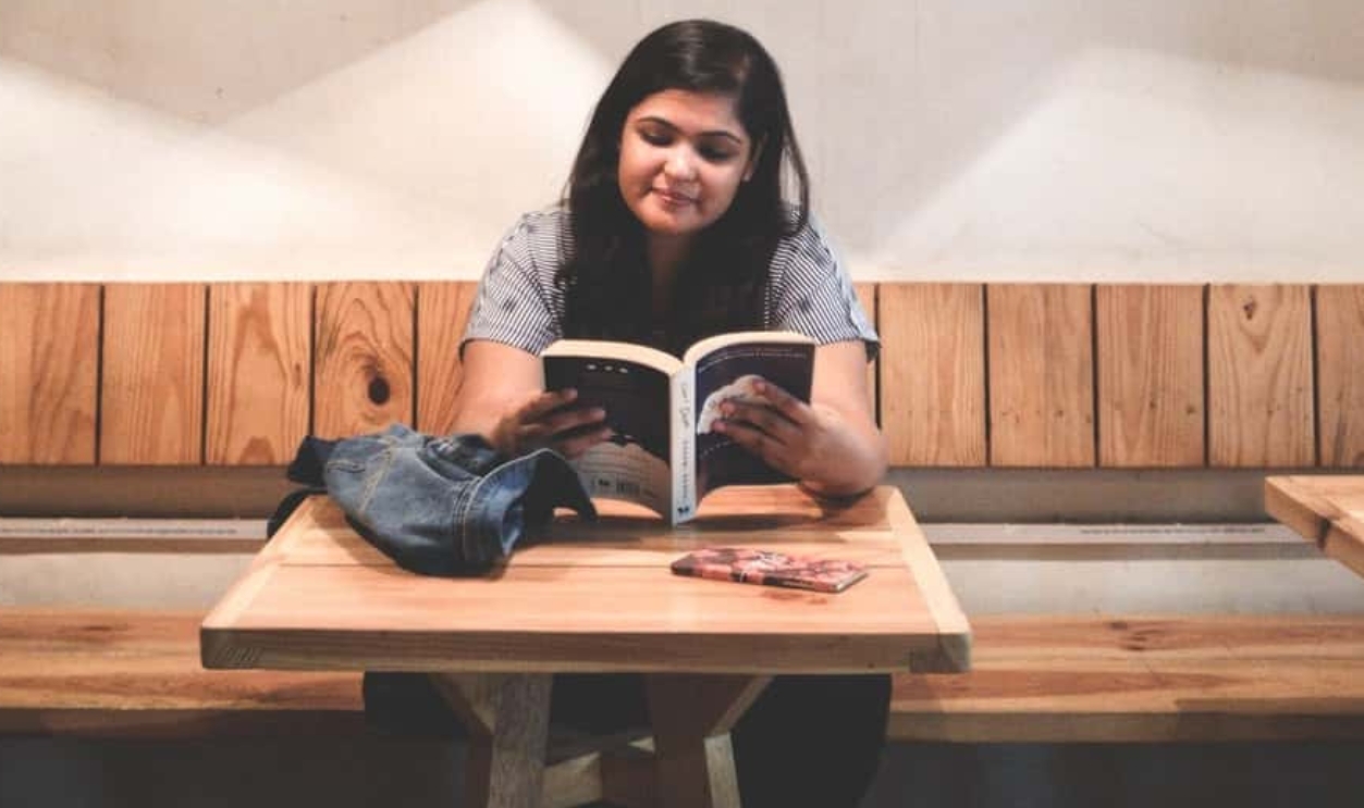 Woman Reading Book Inside The Library