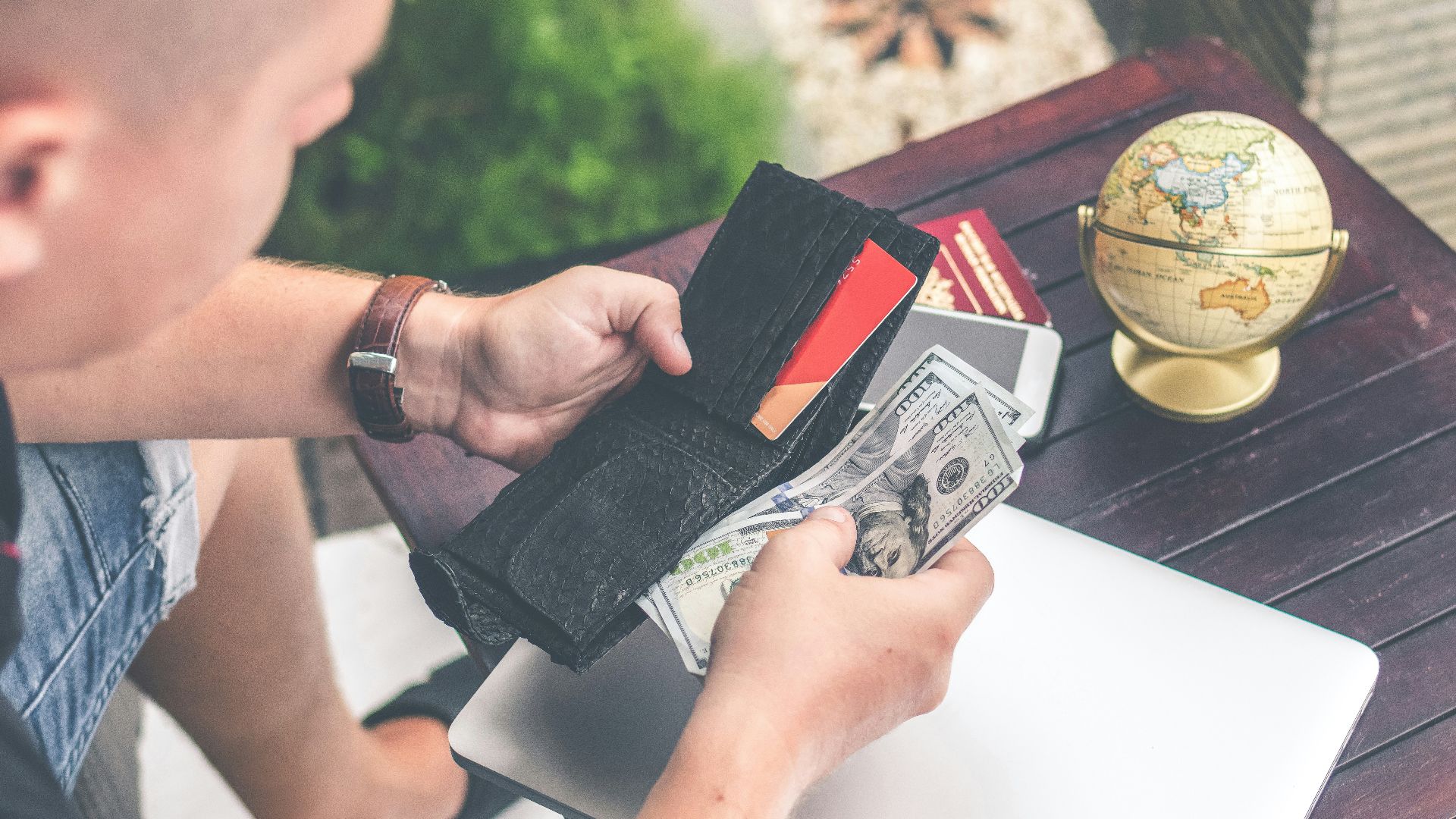 person holding wallet and US dollar bills