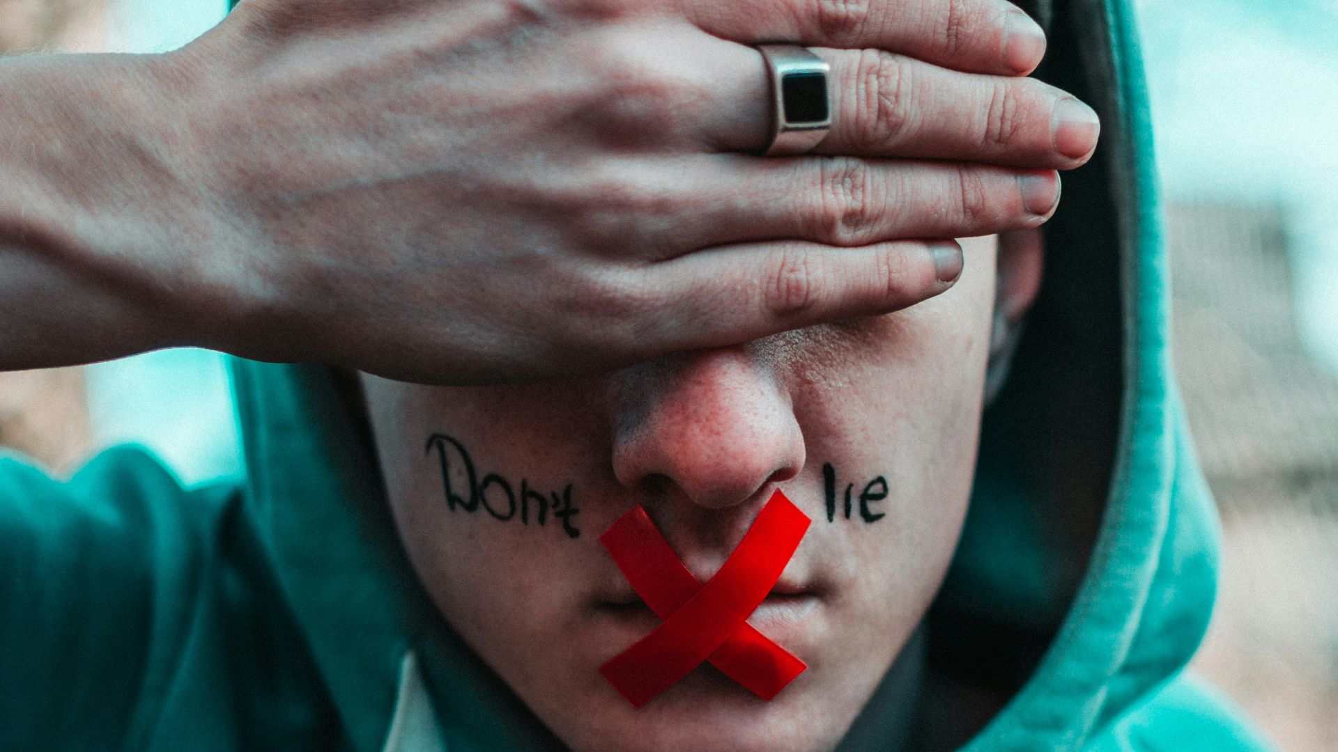 man in teal hoodie with i love you text
