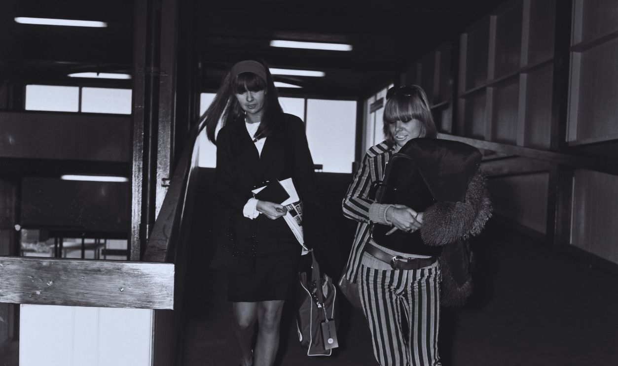 Gettyimages - 1281889404, Chrissie And Anita Models Chrissie Shrimpton (left) and Anita Pallenberg (1942 - 2017) leaving London Airport to meet the Rolling Stones, UK, 4th December 1965. Shrimpton is the partner of Mick Jagger, while Pallenberg is dating Brian Jones
