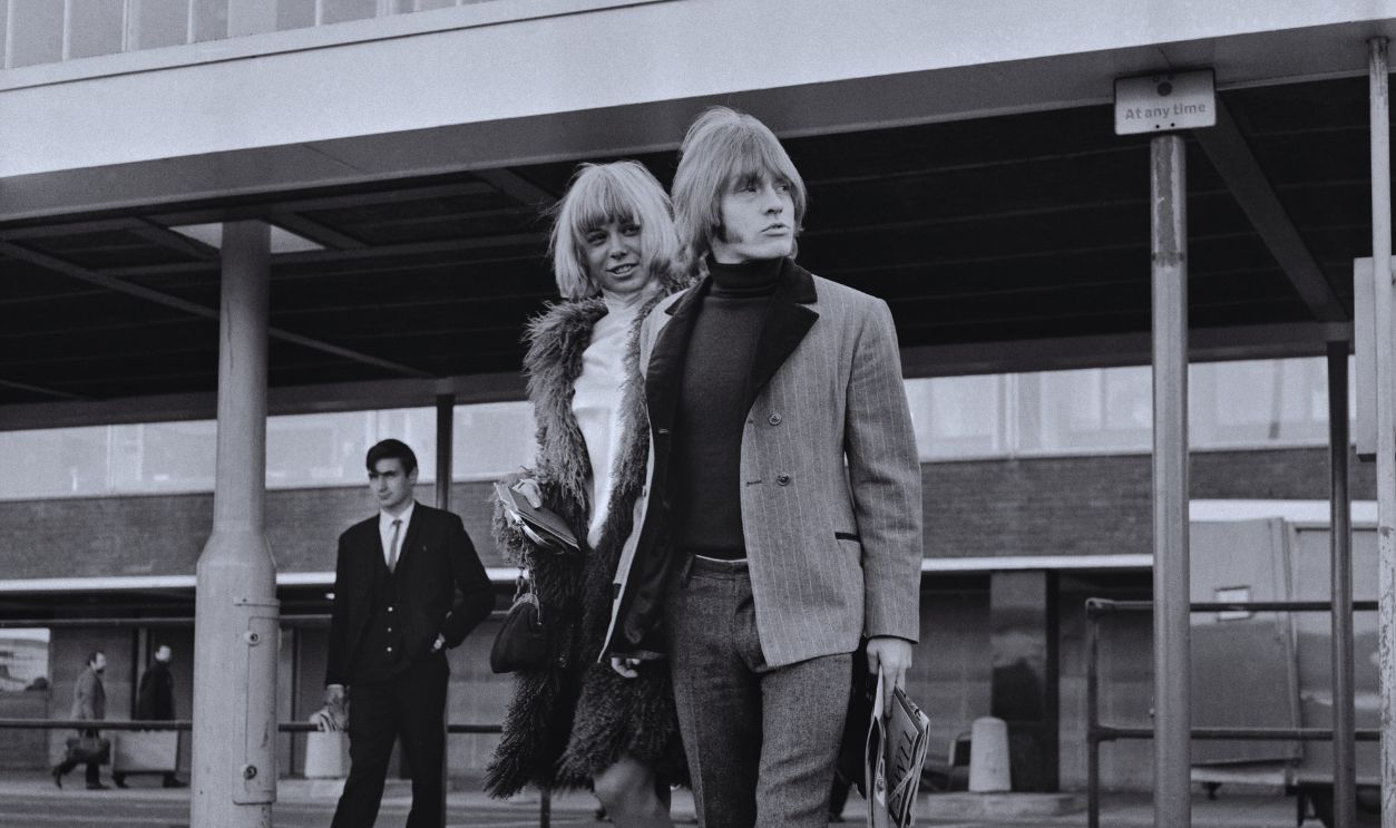 Gettyimages - 2189220541, Brian Jones, Anita Pallenberg, 1966 Rolling Stones guitarist Brian Jones with his girlfriend, actress, artist and fashion model Anita Pallenberg, London Airport, December 3rd 1966