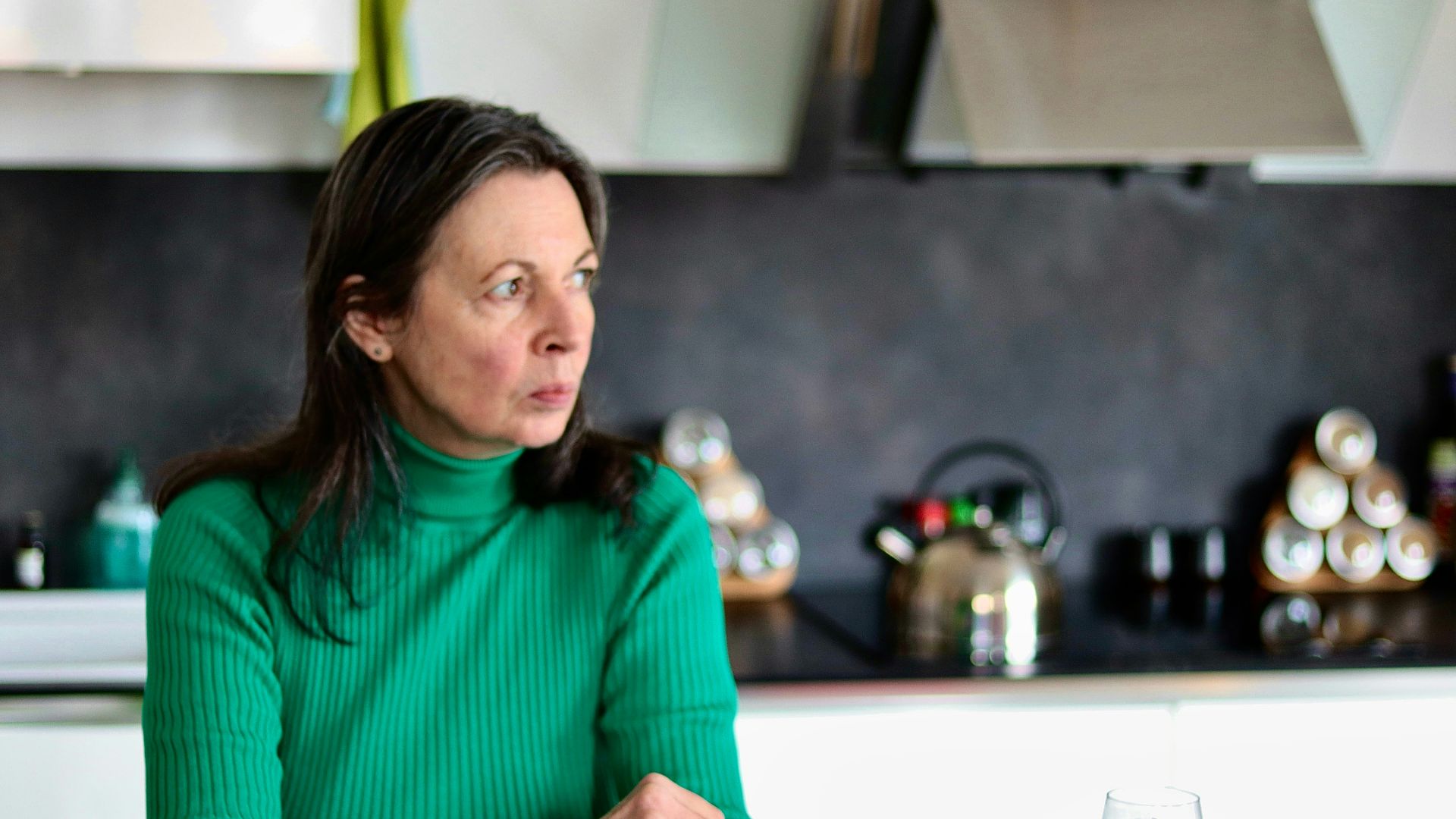 a woman sitting at a table in a kitchen