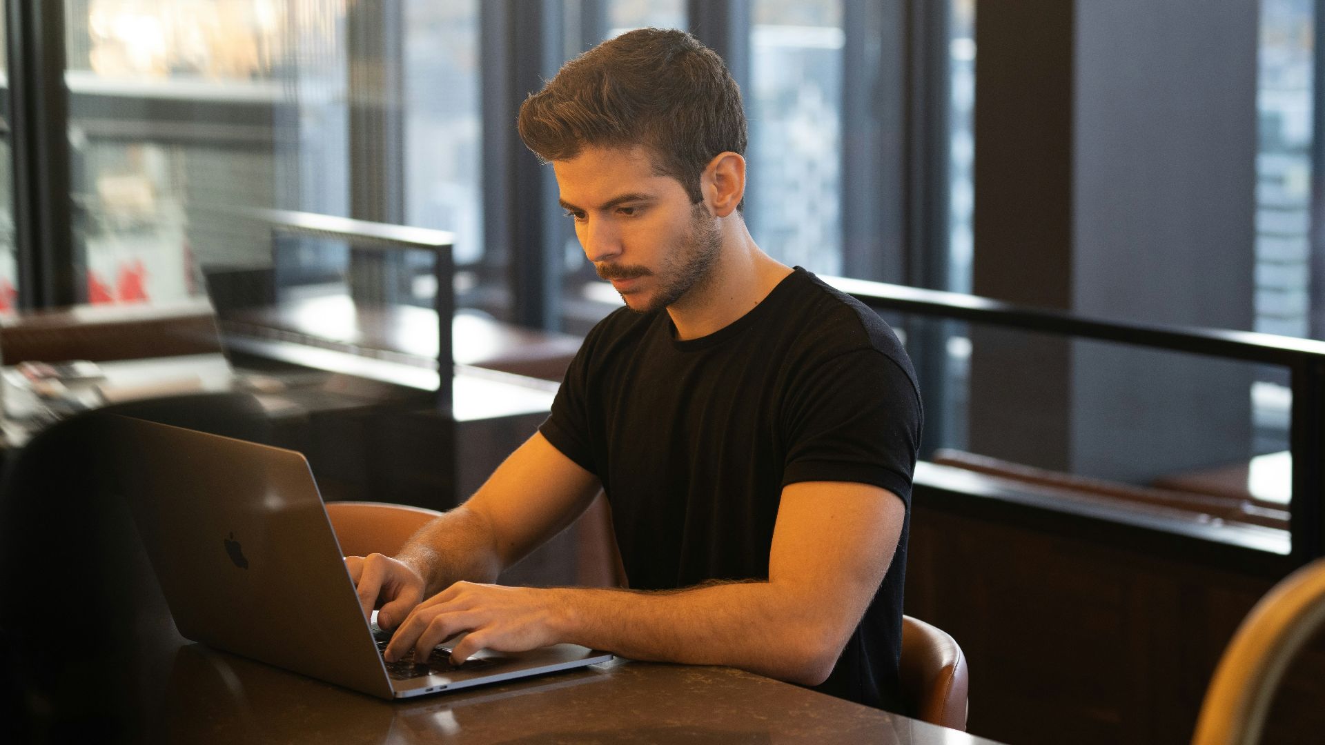 man in black crew neck t-shirt using macbook