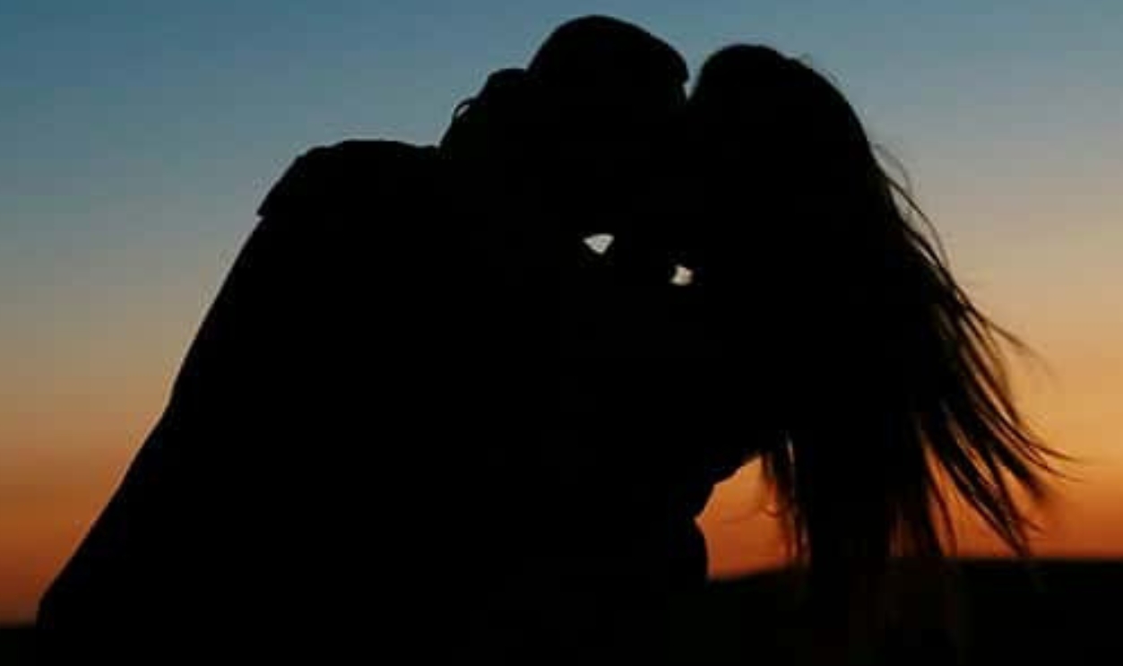 Silhouette Of Couple Kissing During Golden Hour