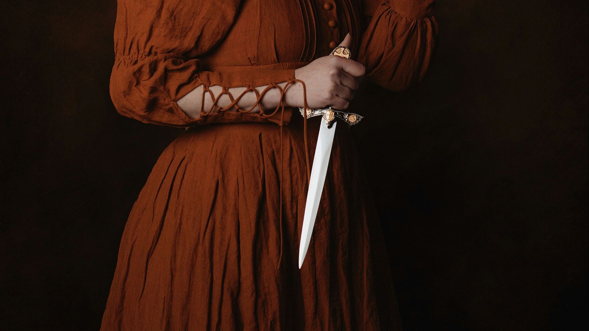 a woman in a brown dress holding a knife