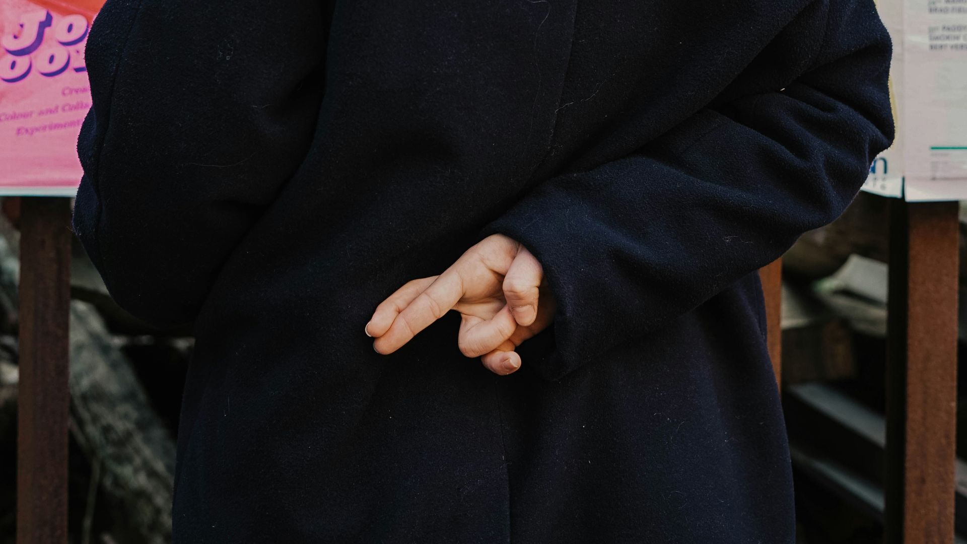 woman in blue hoodie standing in front of white and red kanji text signage