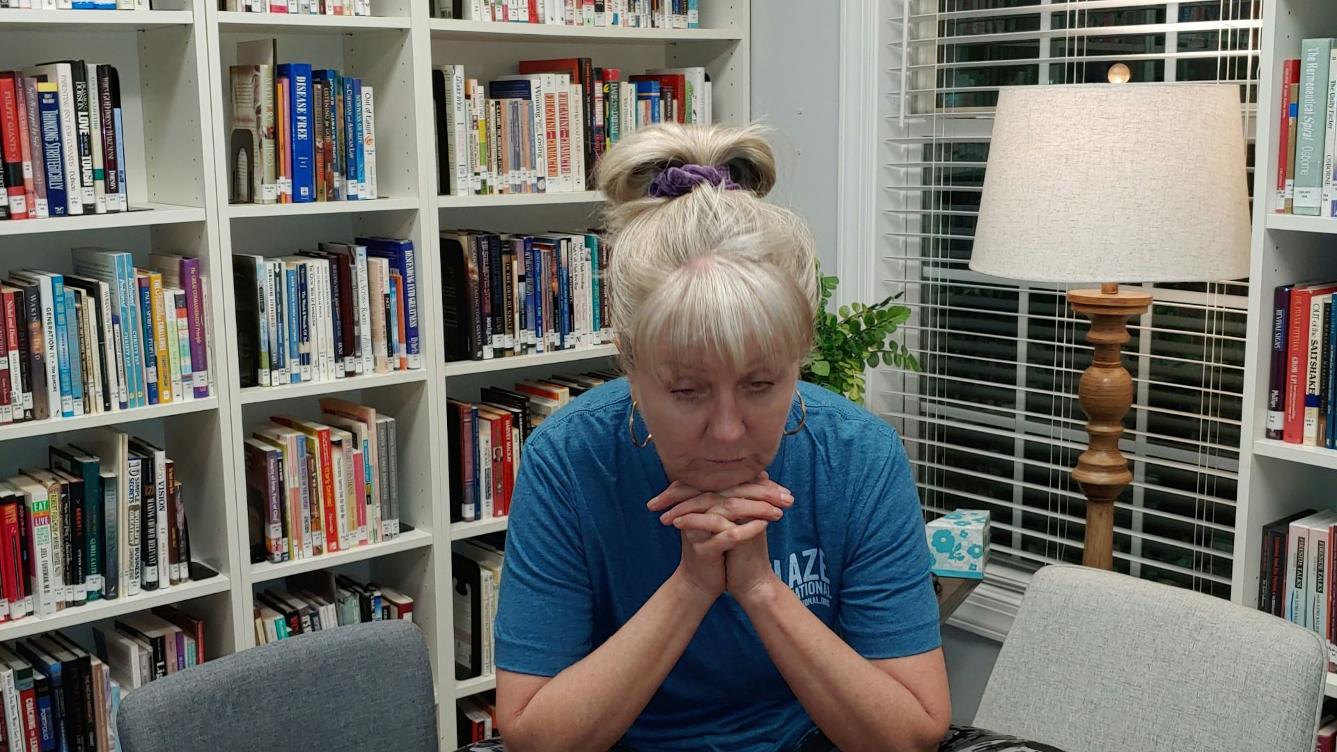 a woman sitting on a table in front of a bookshelf
