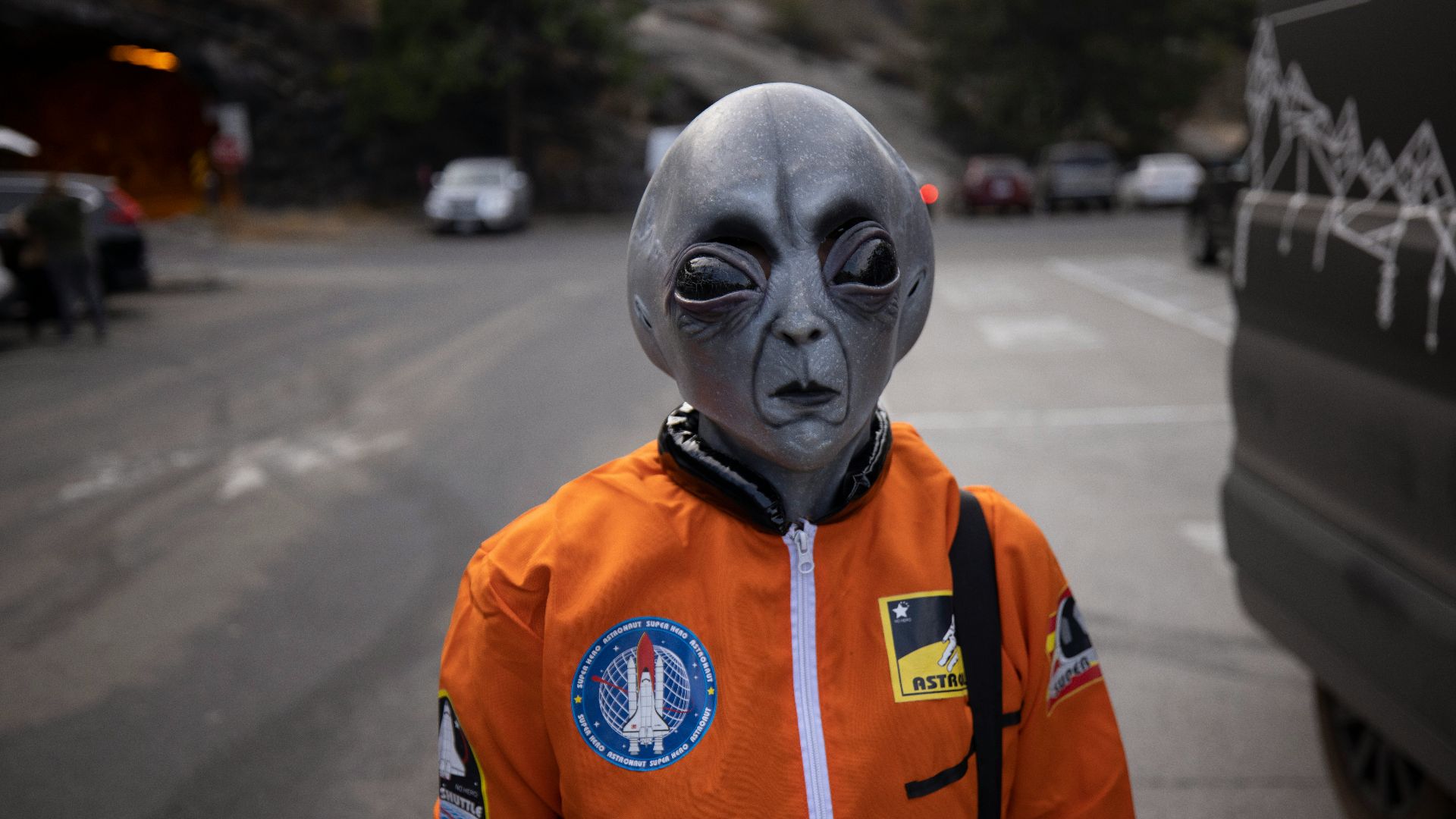 man in orange and white zip up jacket wearing white mask