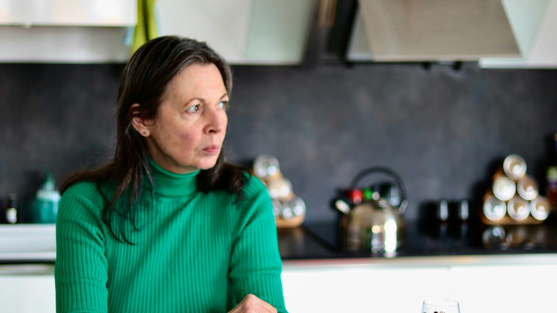 a woman sitting at a table in a kitchen