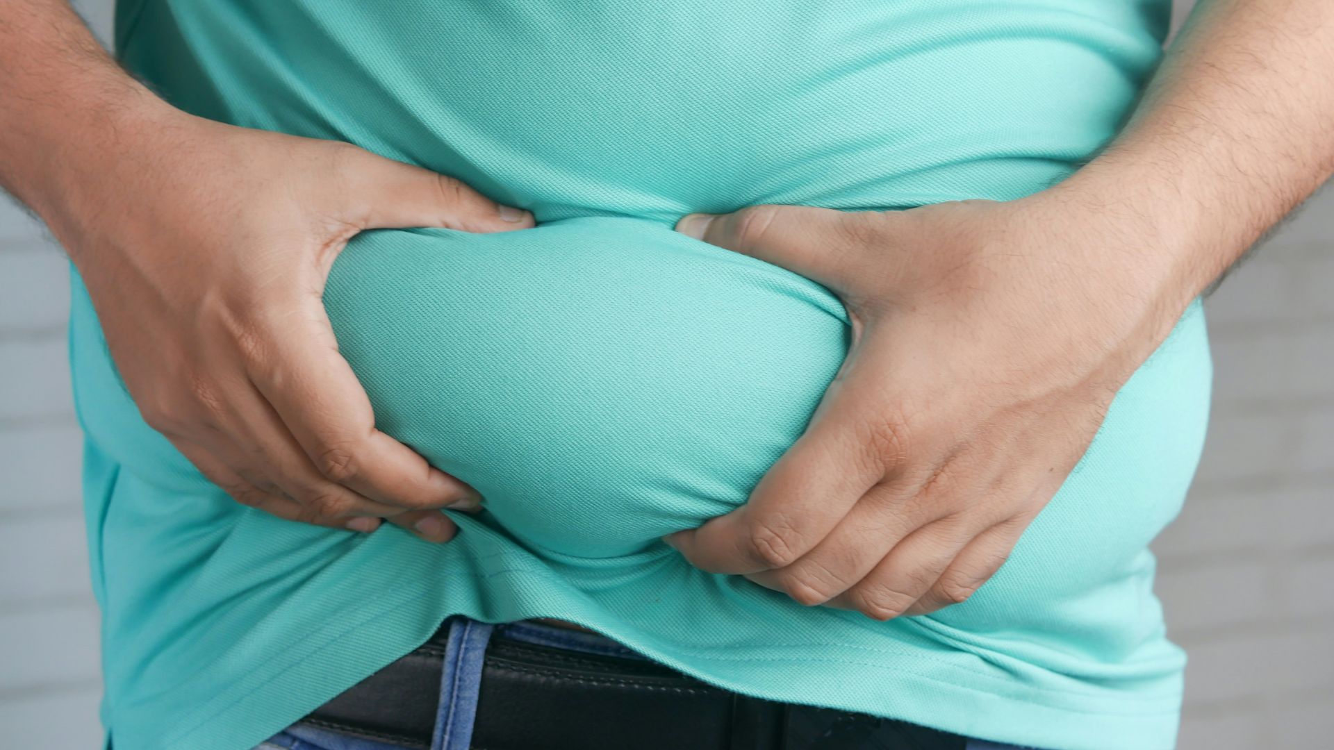 a man holding his stomach with his hands