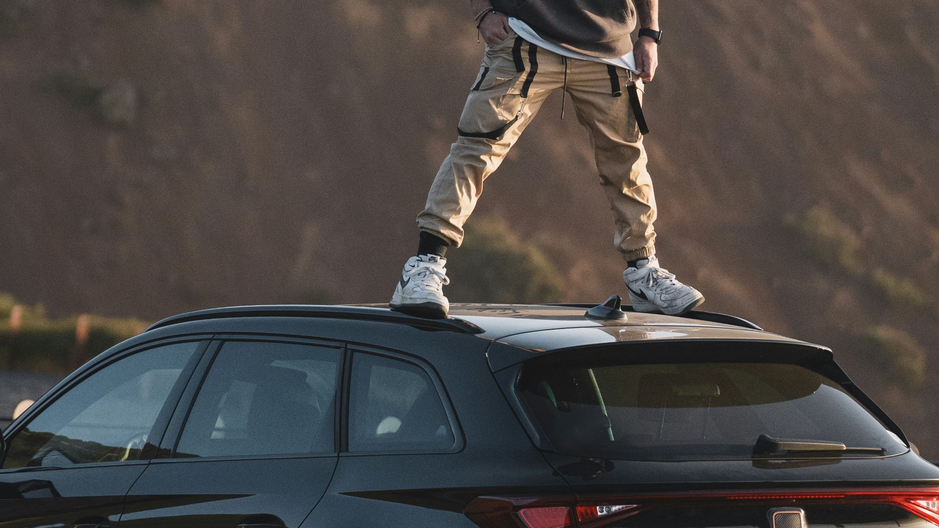 a man standing on top of a car