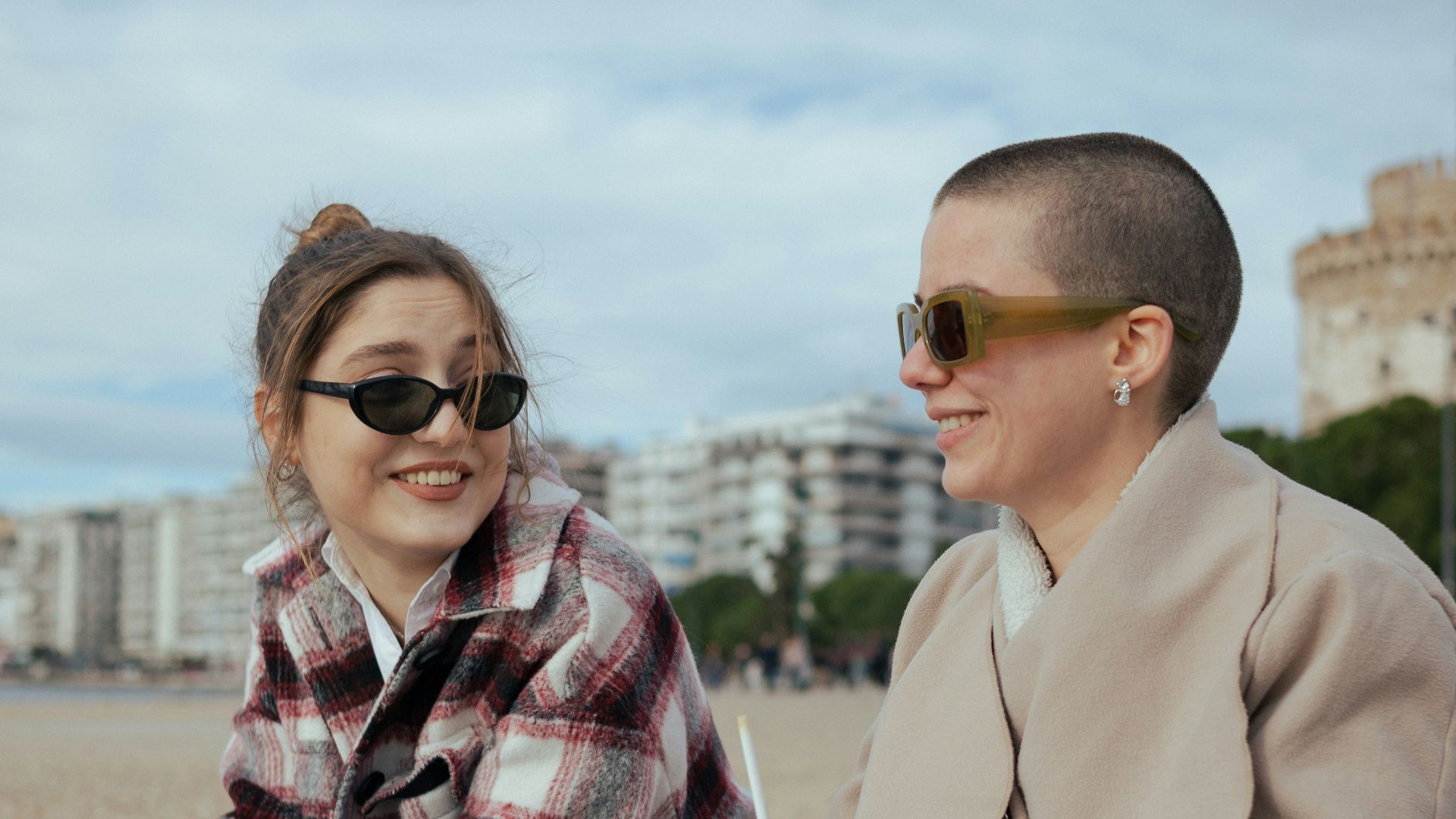a woman sitting next to a man on a bench