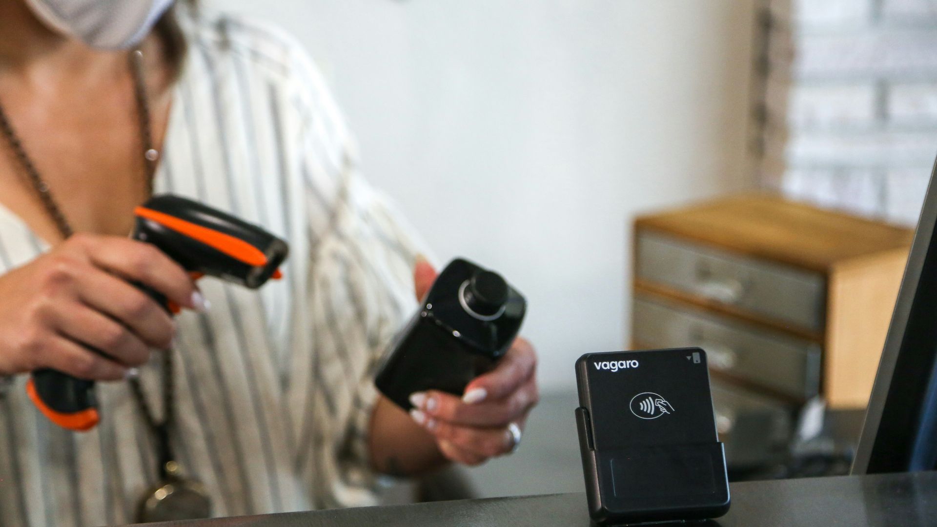 A woman wearing a face mask holding two cameras
