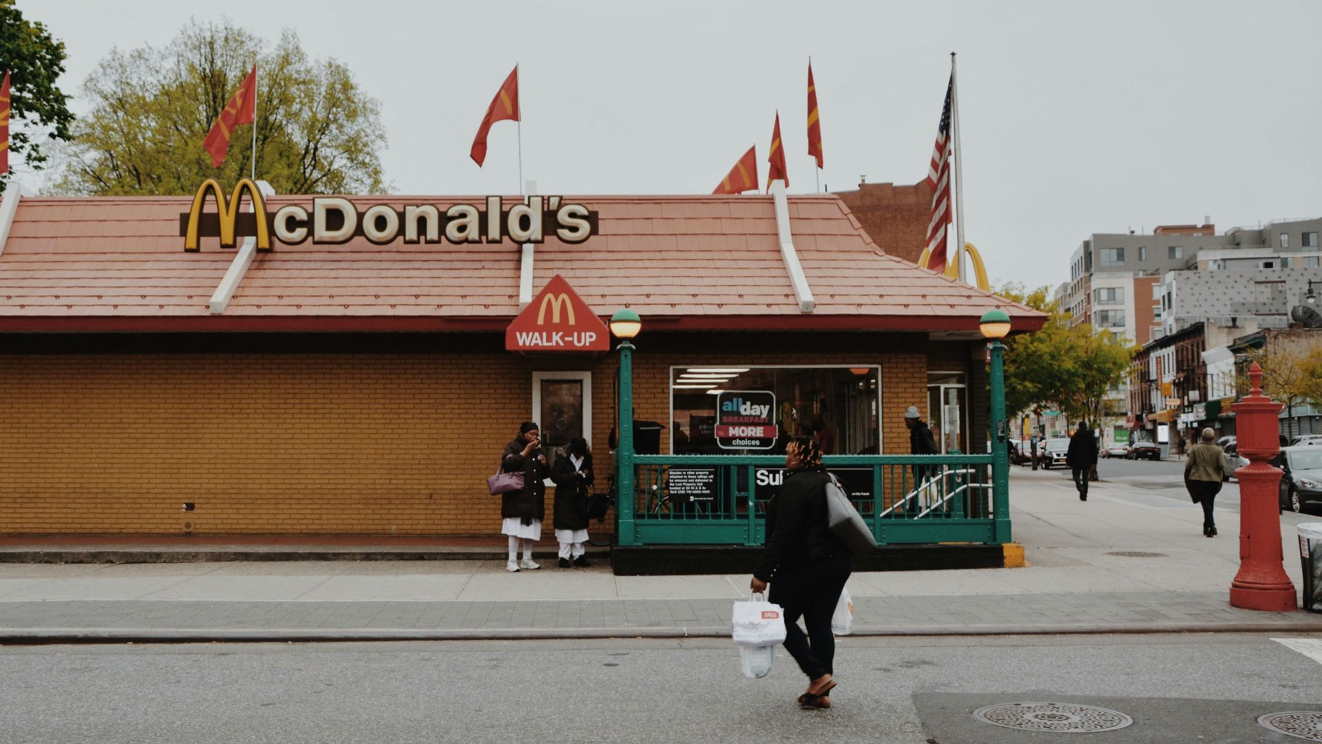 woman walking towards McDonald's branch during daytime