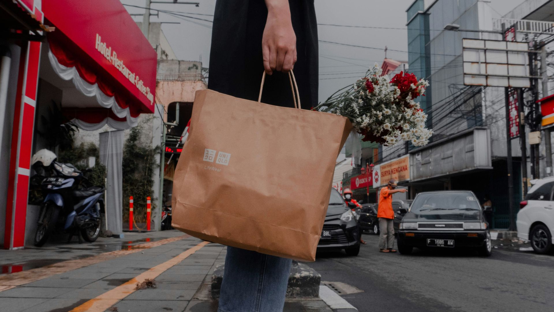 a person holding a brown bag on a city street