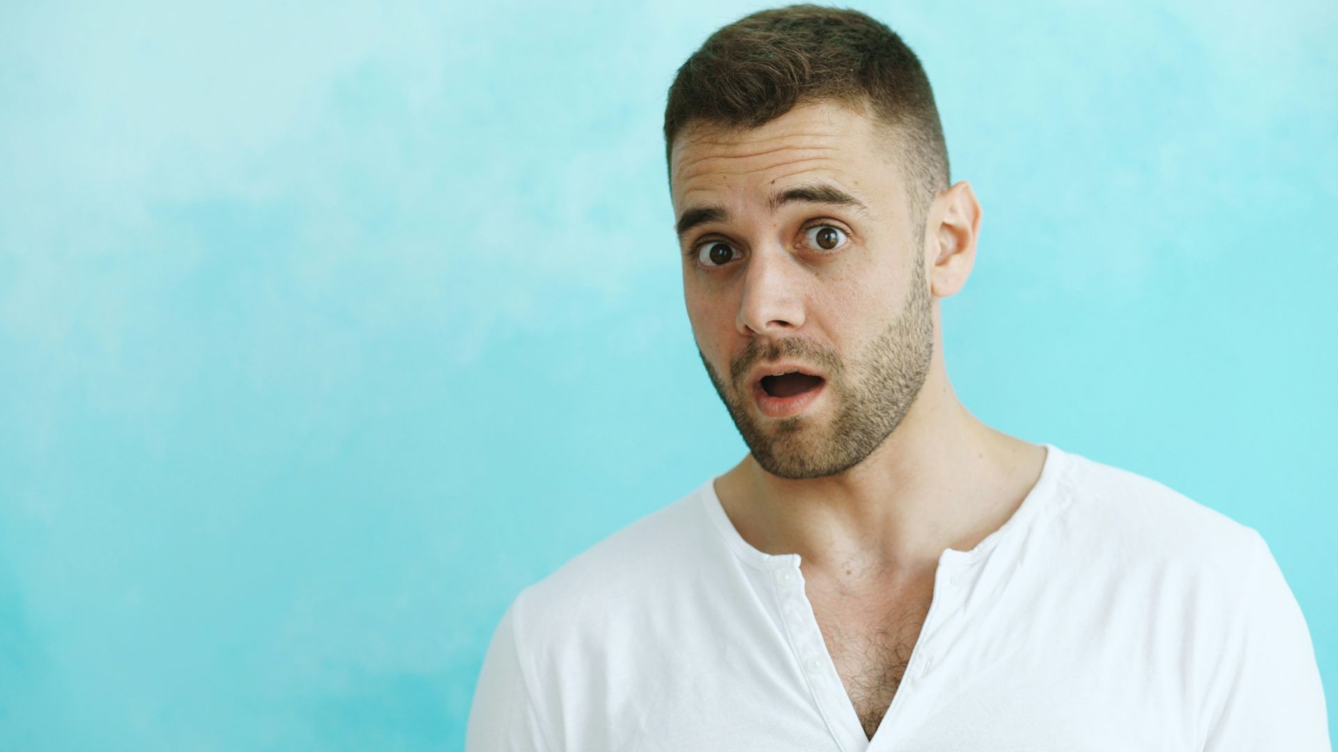 Man with surprised expression against blue background