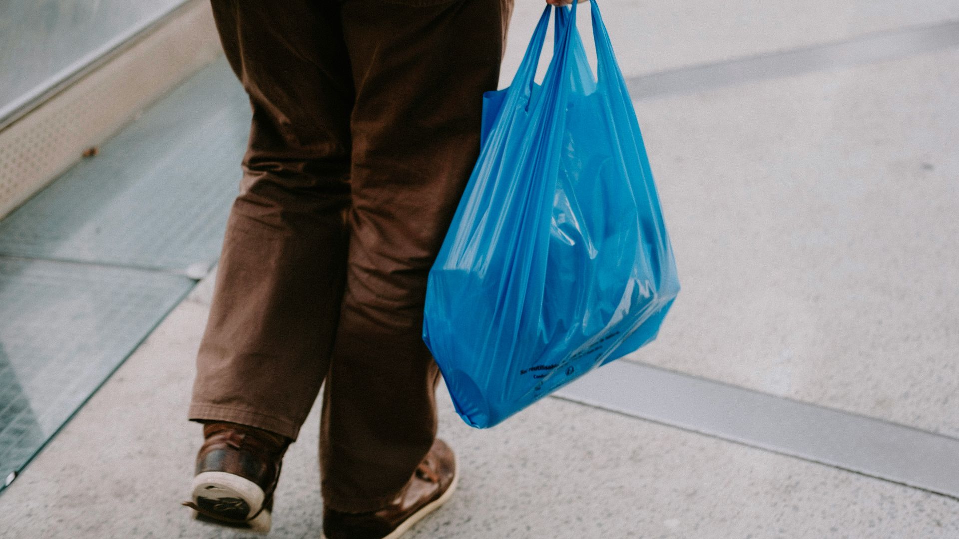 a person with a blue bag walking down an escalator