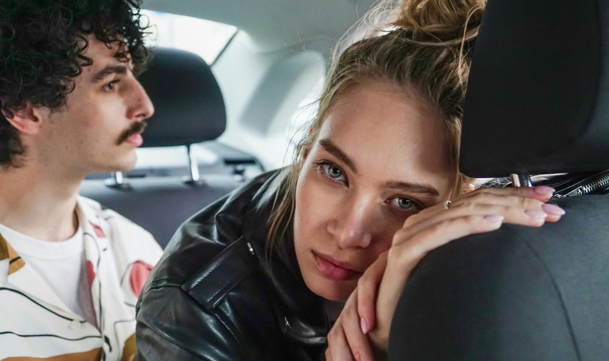 A Woman Leaning On A Car Seat
