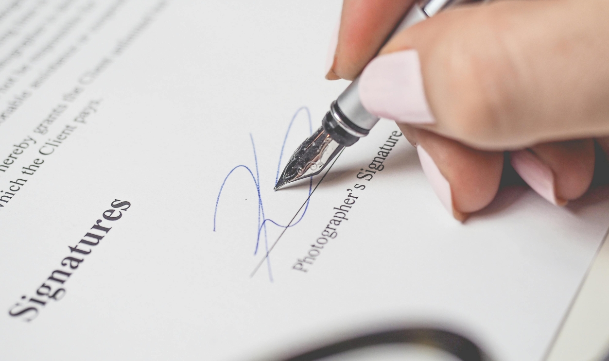 Person Holding Silver Pen Signing
