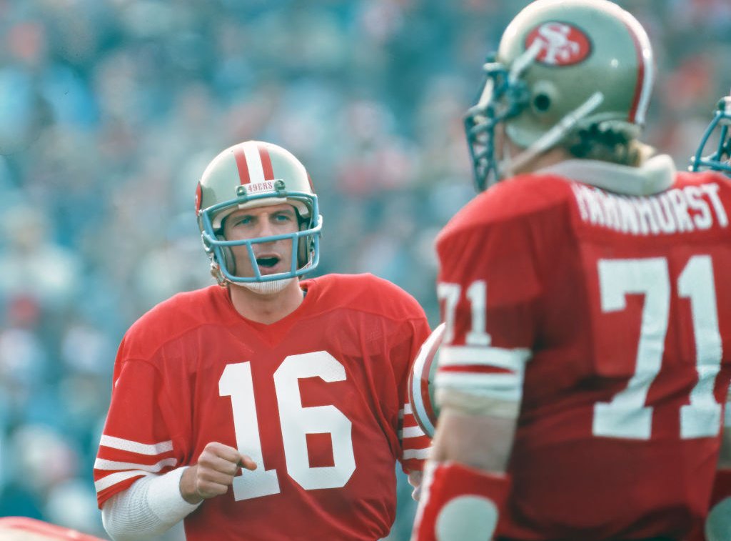 Quarterback Joe Montana #16 of the San Francisco 49ers huddles with the offense, including offensive lineman Keith Fahnhurst #71