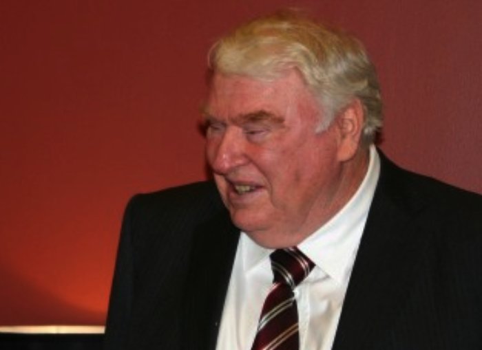 Coach John Madden in a black suit