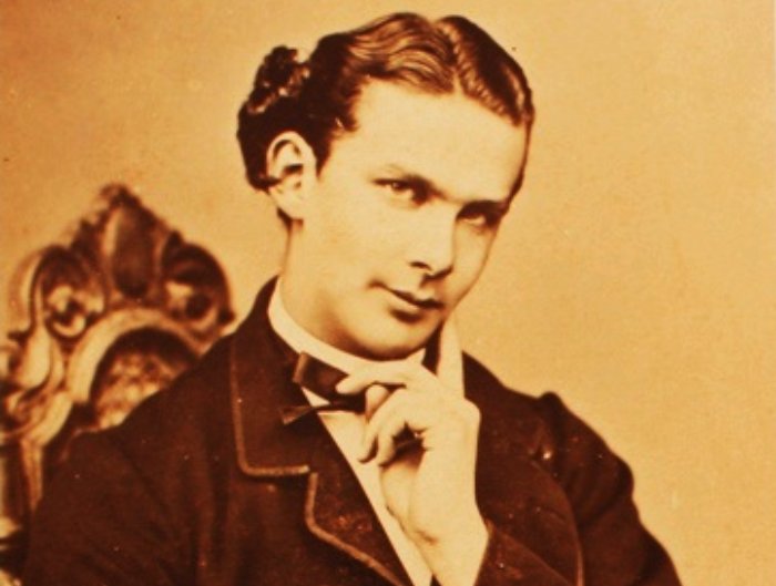 Ludwig II of Bavaria in a suit, sitting on a chair