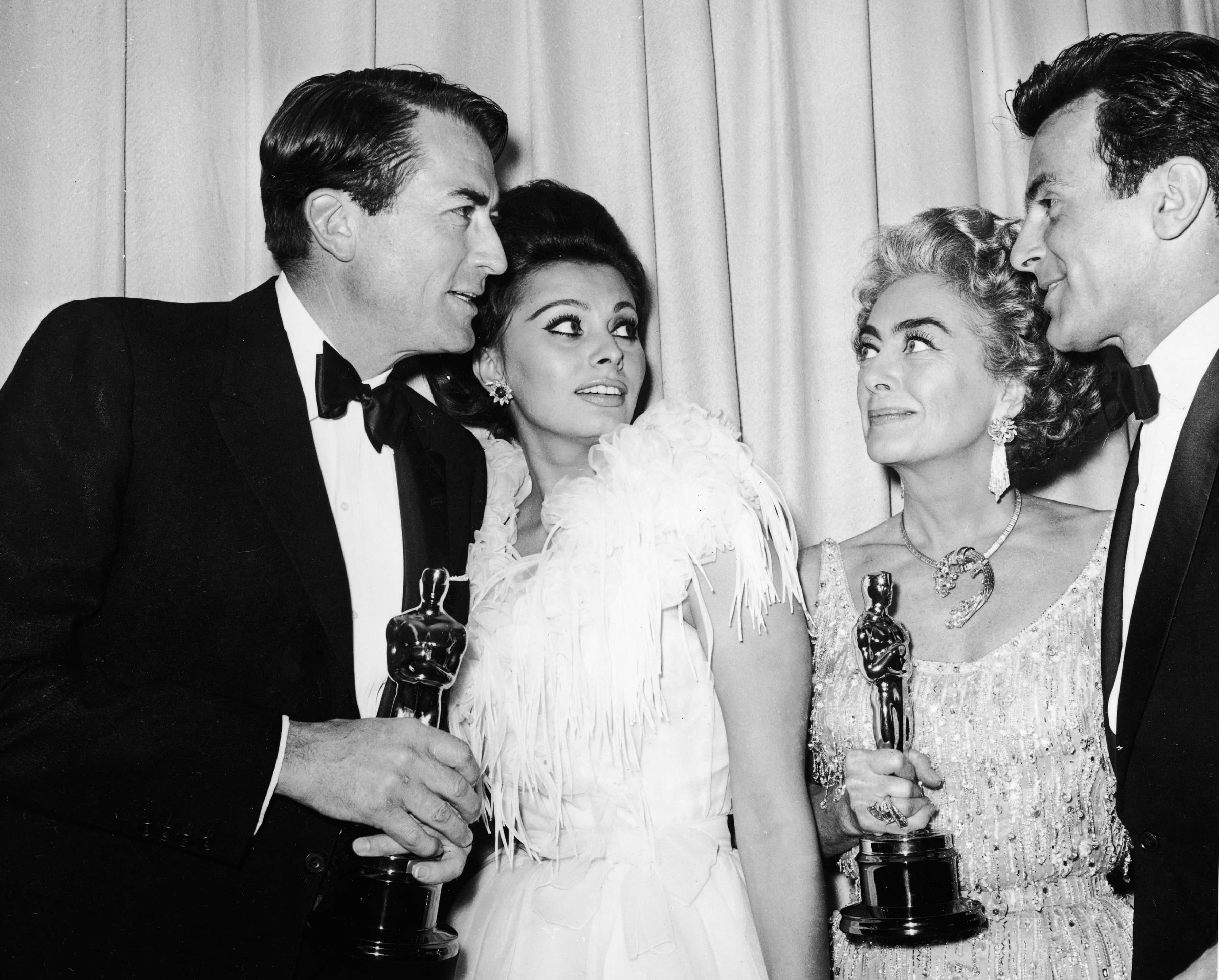 Actors Gregory Peck (1916 - 2003), Sophia Loren, Joan Crawford (1904 - 1977) and Maximilian Schell stand backstage at the Academy Awards