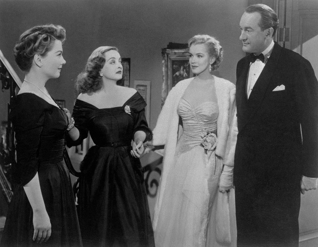 Anne Baxter, Bette Davis, Marilyn Monroe, and George Sanders in a scene from a movie: All About Eve