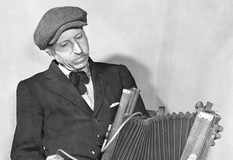 Langley Collyer wearing a suit and a hat