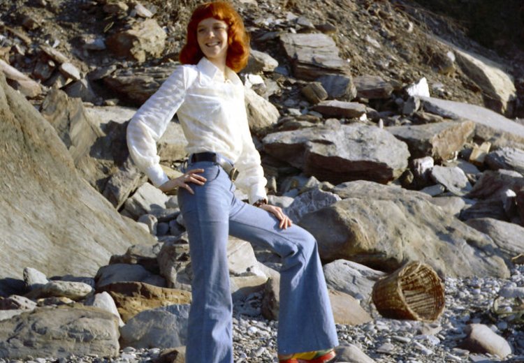 Tall natural redhead Erika on a North Devon beach in the UK, wearing bell bottom jeans