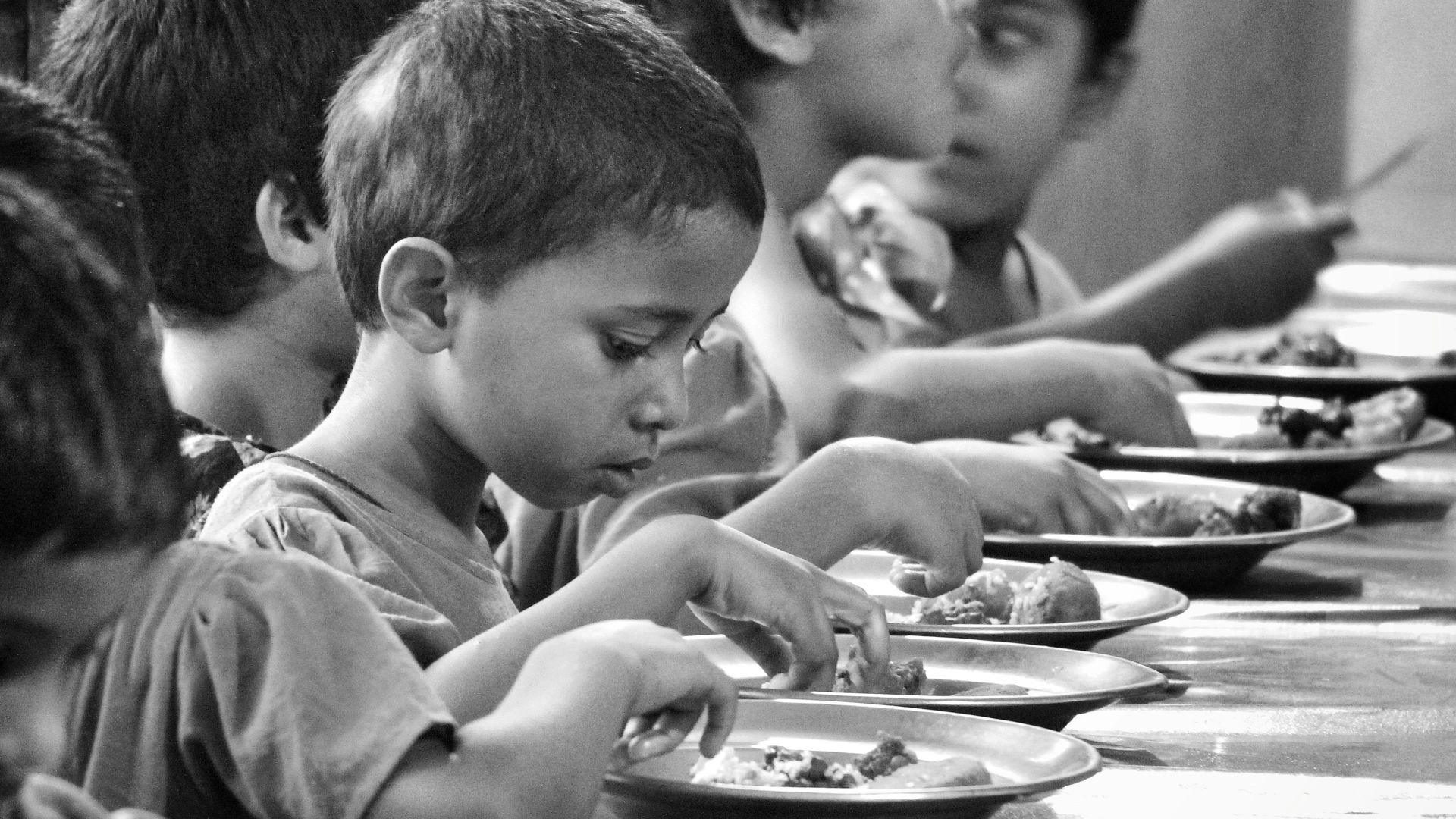 boy and girl eating on table