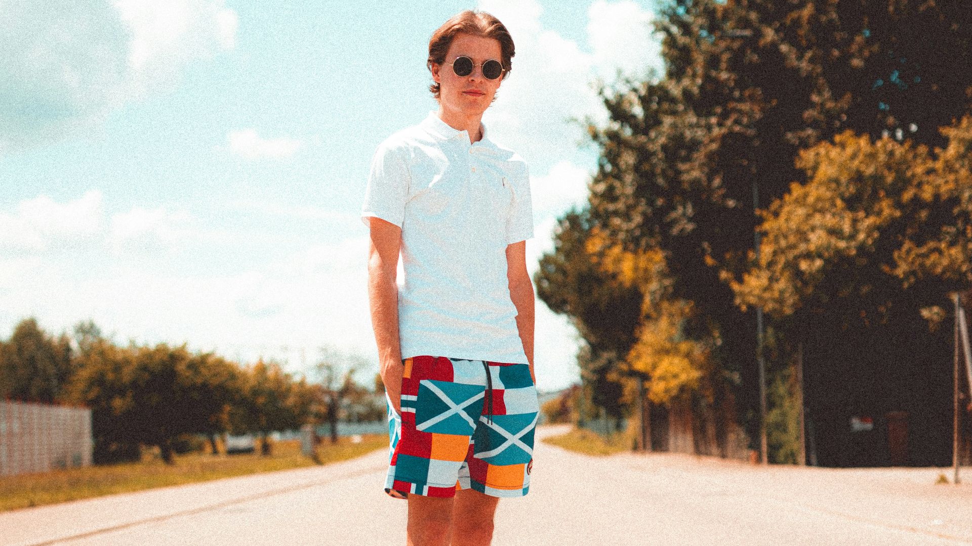 woman in white crew neck t-shirt and blue denim shorts standing on road during daytime